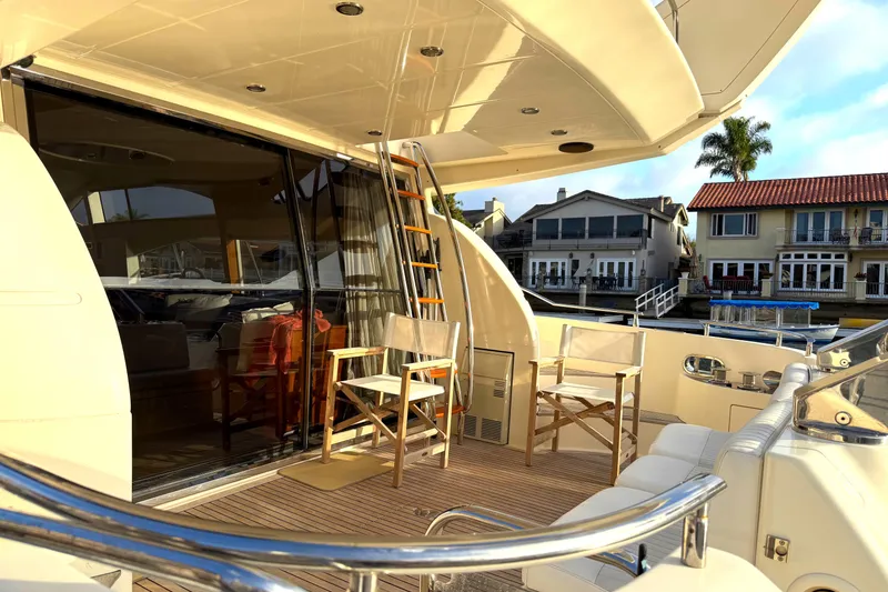 Slide: The Image of Luxurious 1996 Azimut 54 yacht deck with seating, docked near waterfront homes. - 8