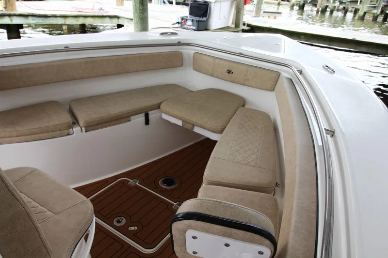 Slide: The Image of 2023 Sea Pro 259 DLX boat interior with cushioned seating and wood flooring. - 11