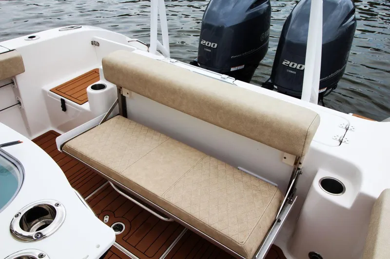 Slide: The Image of 2023 Sea Pro 259 DLX boat interior with seating and twin Yamaha engines. - 13