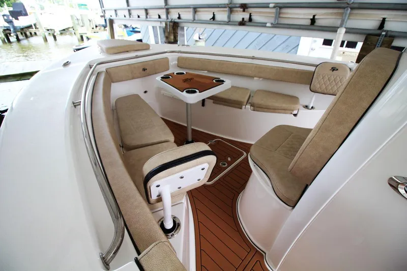 Slide: The Image of 2023 Sea Pro 259 DLX boat interior with cushioned seating and table. - 14