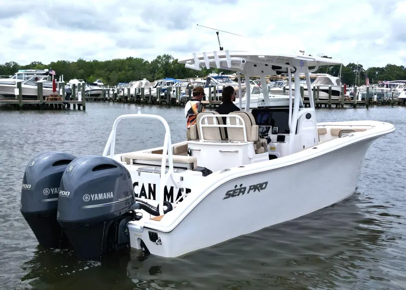 Slide: The Image of 2023 Sea Pro 259 DLX boat with dual Yamaha engines docked at marina. - 2