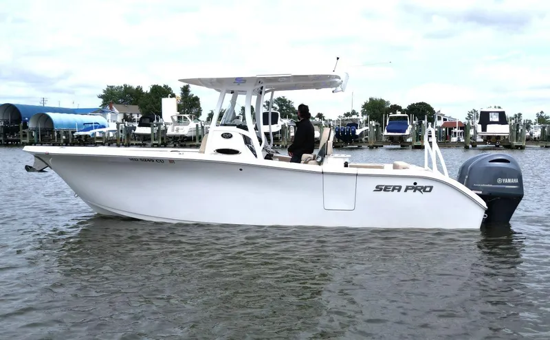 Slide: The Image of 2023 Sea Pro 259 DLX boat on water with Yamaha engine, docked at marina. - 4