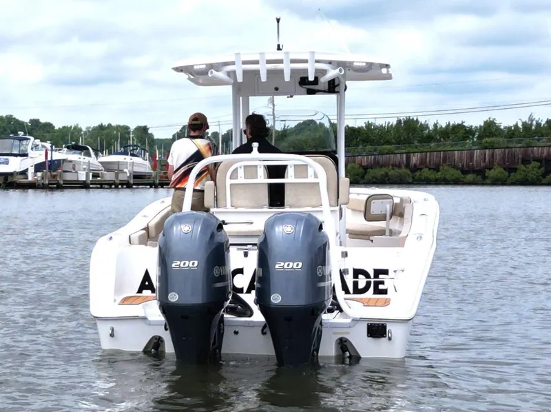 Slide: The Image of 2023 Sea Pro 259 DLX boat with dual Yamaha 200 engines on a calm waterway. - 6