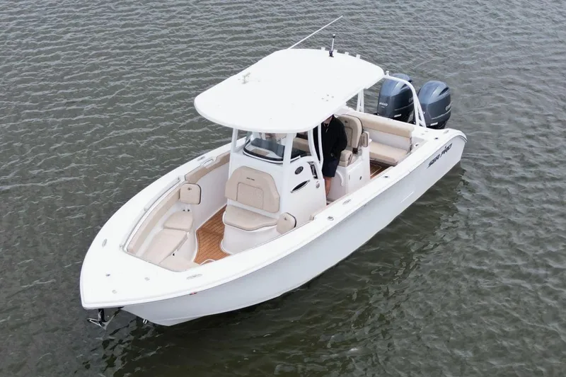 Slide: The Image of 2023 Sea Pro 259 DLX boat on water, featuring dual engines and spacious seating. - 9