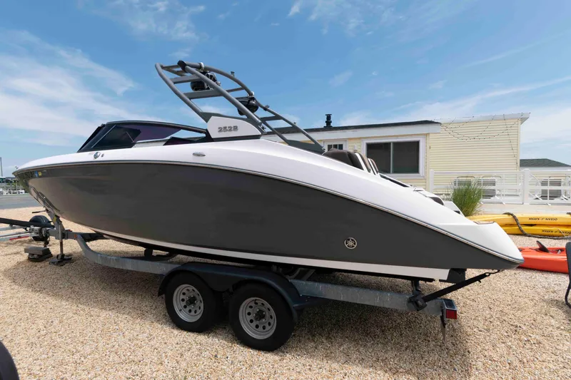 Slide: The Image of 2021 Yamaha Boats 252S on trailer, parked outdoors under clear sky. - 10