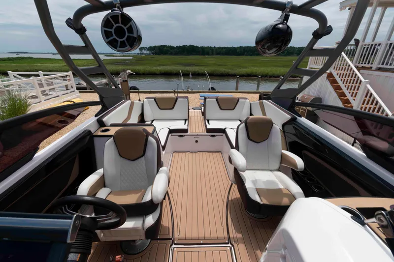Slide: The Image of 2021 Yamaha Boats 252S interior with luxurious seating and modern design by the water. - 6