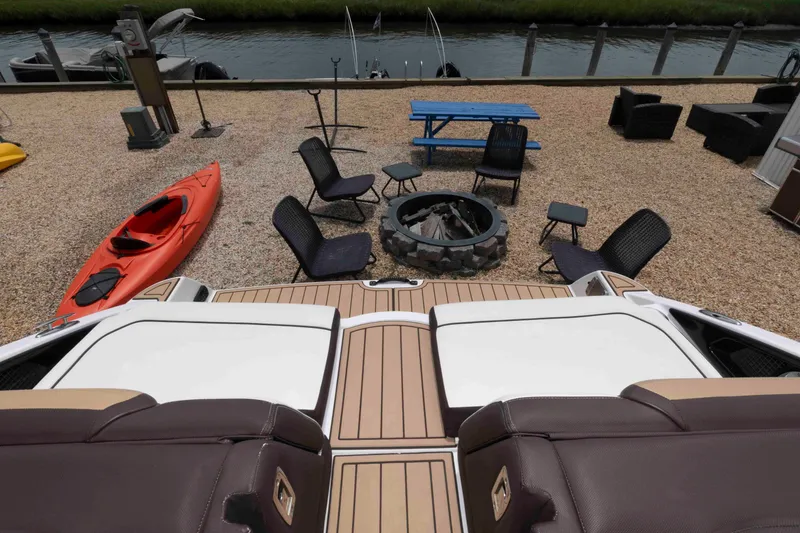 Slide: The Image of Yamaha Boats 252S 2021 model near a fire pit, kayak, and outdoor seating by the water. - 9