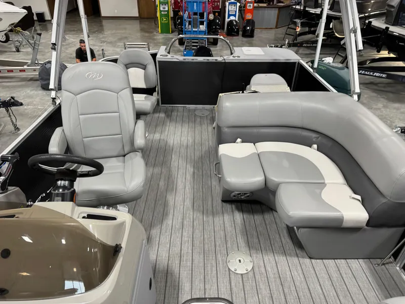 Slide: The Image of 2018 Manitou 23 Aurora LE pontoon boat interior with gray seating and steering console. - 10