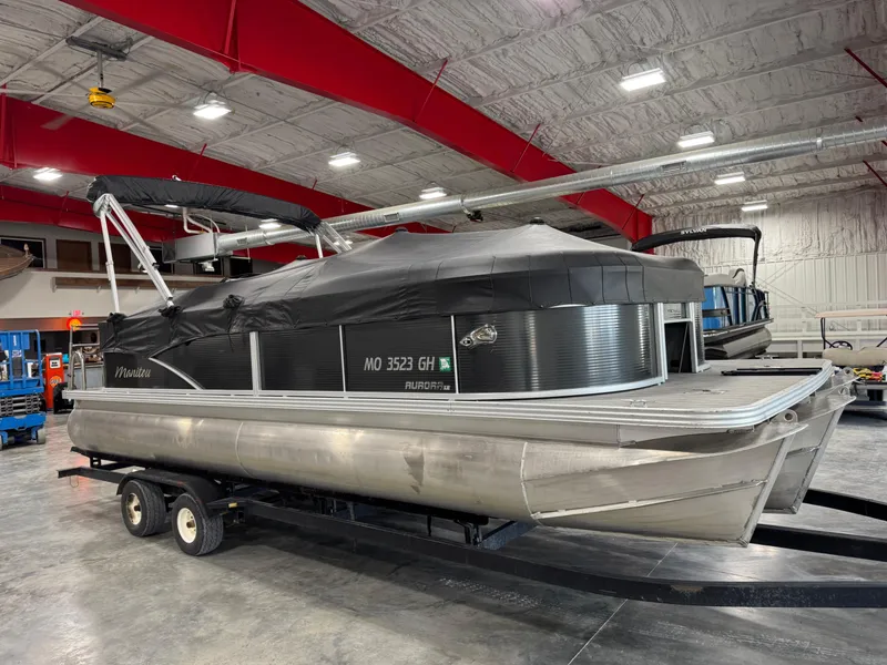 Slide: The Image of 2018 Manitou 23 Aurora LE pontoon boat on trailer in indoor storage facility. - 12