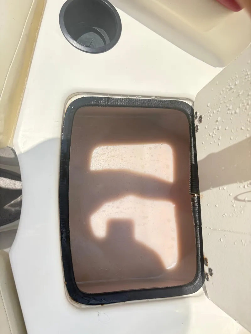 Slide: The Image of Open storage compartment on a 1999 Stingray 190 LS boat with cup holder nearby. - 10