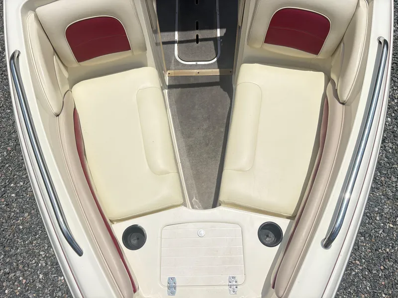 Slide: The Image of 1999 Stingray 190 LS boat interior with cream and red seating, cup holders, and metal railings. - 12