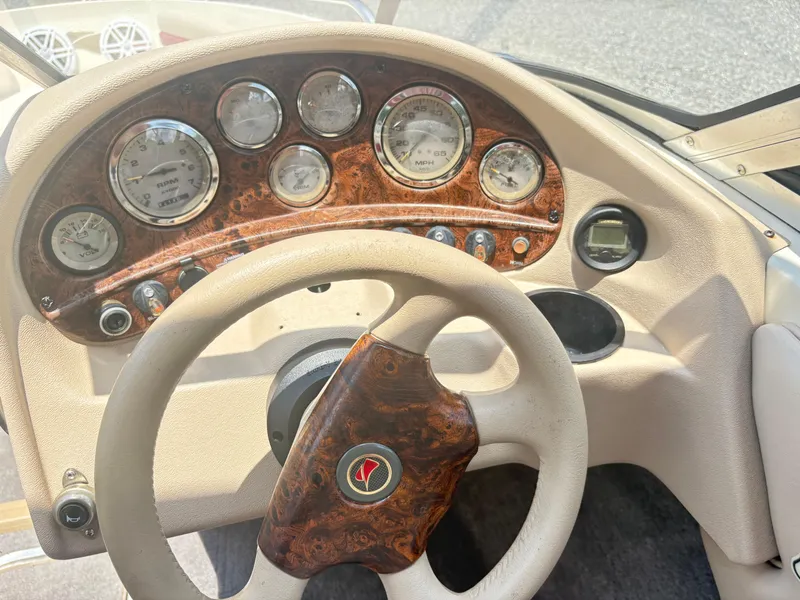 Slide: The Image of 1999 Stingray 190 LS boat dashboard with wood accents and multiple gauges. - 14