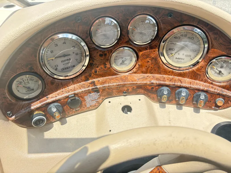Slide: The Image of Dashboard of a 1999 Stingray 190 LS boat with wood grain finish and gauges. - 15