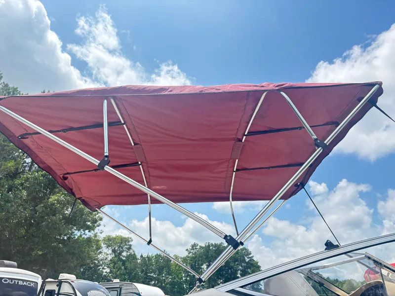Slide: The Image of Red bimini top on 1999 Stingray 190 LS boat under blue sky. - 6