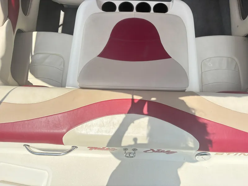 Slide: The Image of 1999 Stingray 190 LS boat interior with red and beige seating and cup holders. - 8