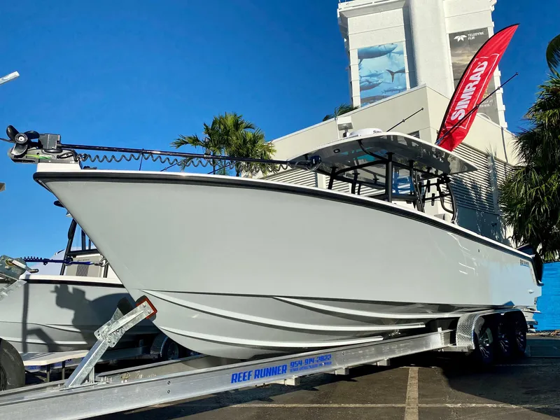 The Image of Reef Runner 230 C Open 2026 boat docked, surrounded by palm trees. - 0
