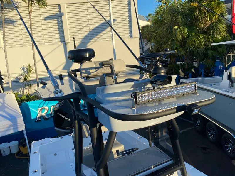 Slide: The Image of Reef Runner 230 C Open 2026 boat in water near a dock. - 1