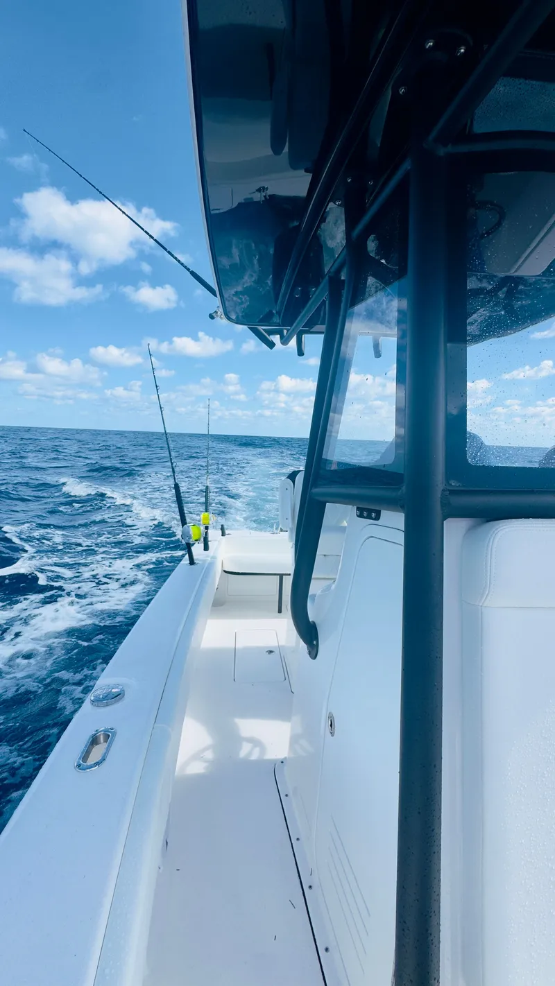 Slide: The Image of Reef Runner 230 C Open 2026 on open sea under sunny skies. - 26