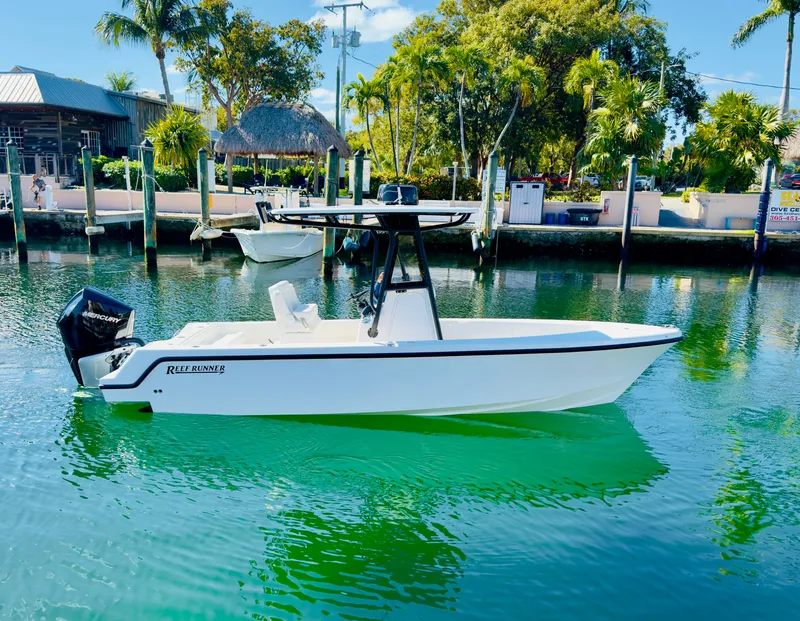 Slide: The Image of Reef Runner 230 C Open 2026 boat on calm water. - 27