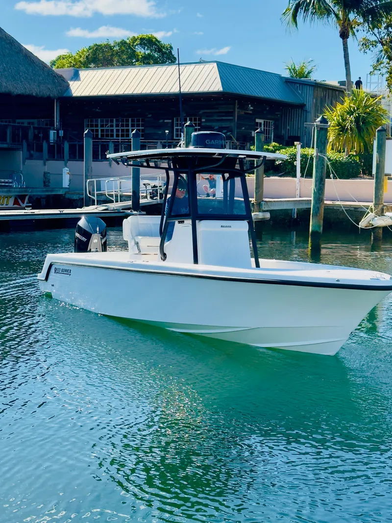 Slide: The Image of Reef Runner 230 C Open 2026 boat on water near dock. - 29