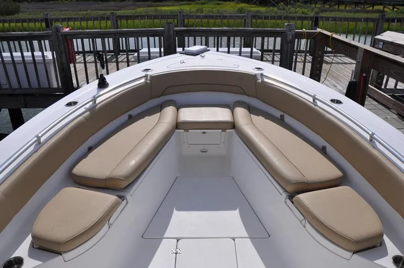 Slide: The Image of 2017 Sportsman Open 282 Center Console boat with tan cushioned seating at dock. - 30