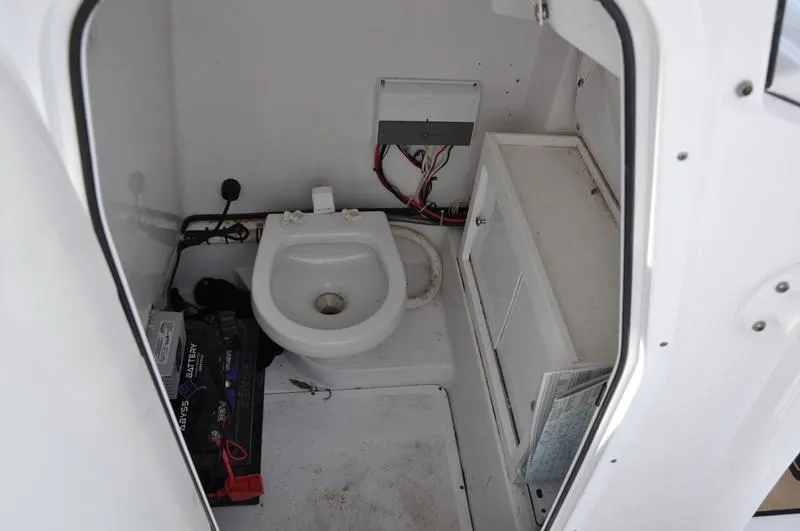 Slide: The Image of 2017 Sportsman Open 282 Center Console boat interior with toilet and battery compartment. - 32