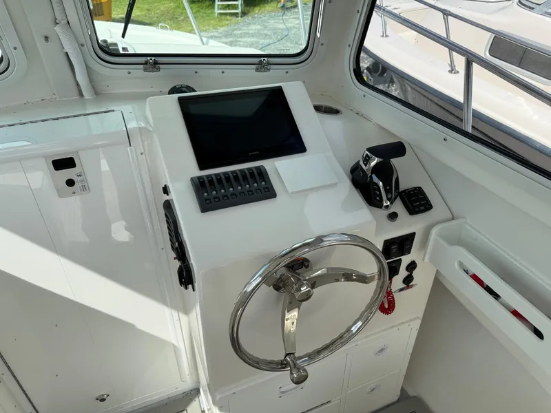 Slide: The Image of 2024 Steiger Craft 23 Miami boat helm with steering wheel and control panel. - 17