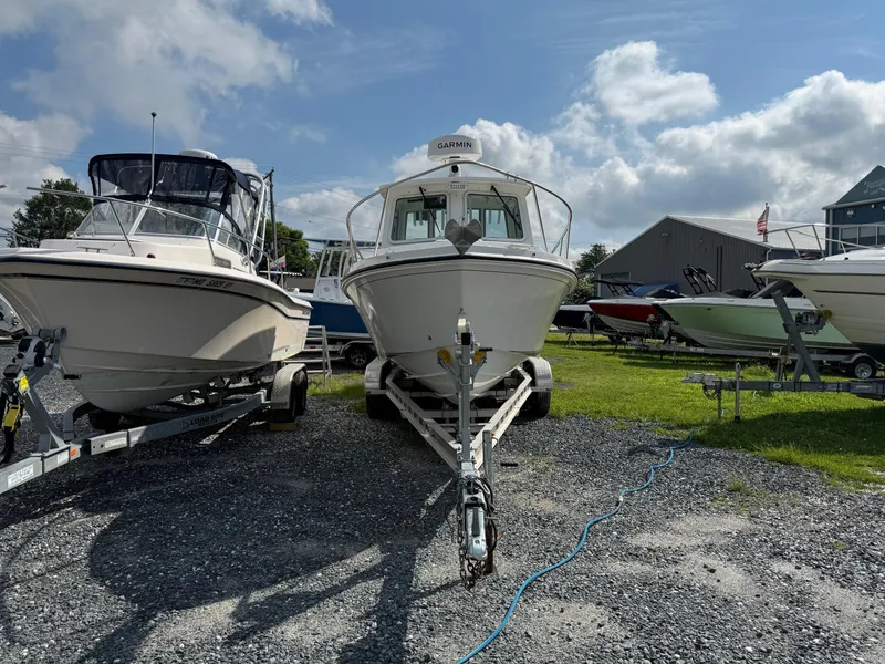 Slide: The Image of 2024 Steiger Craft 23 Miami boat on trailer, displayed outdoors under a partly cloudy sky. - 2