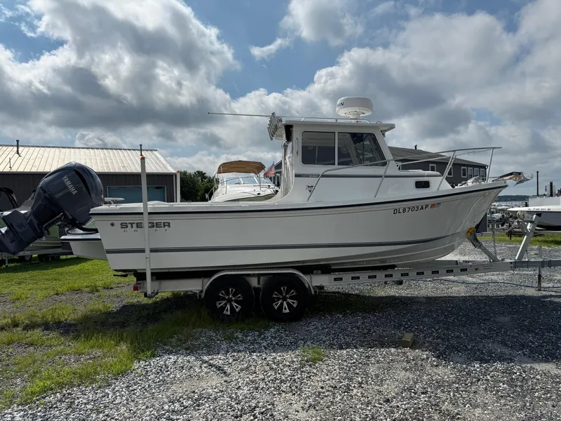 Slide: The Image of 2024 Steiger Craft 23 Miami boat on trailer, parked outdoors under cloudy sky. - 21