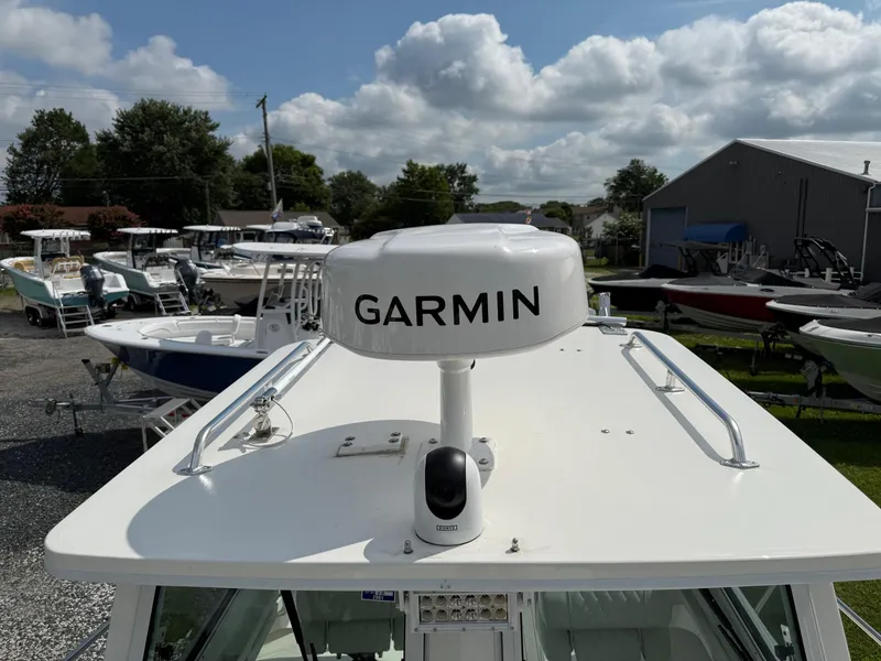 Slide: The Image of 2024 Steiger Craft 23 Miami boat with Garmin radar, parked outdoors under a cloudy sky. - 7