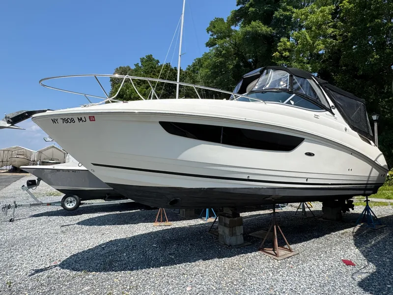 The Image of 2014 Sea Ray 280 Sundancer boat on stands, outdoors, with trees in the background. - 0