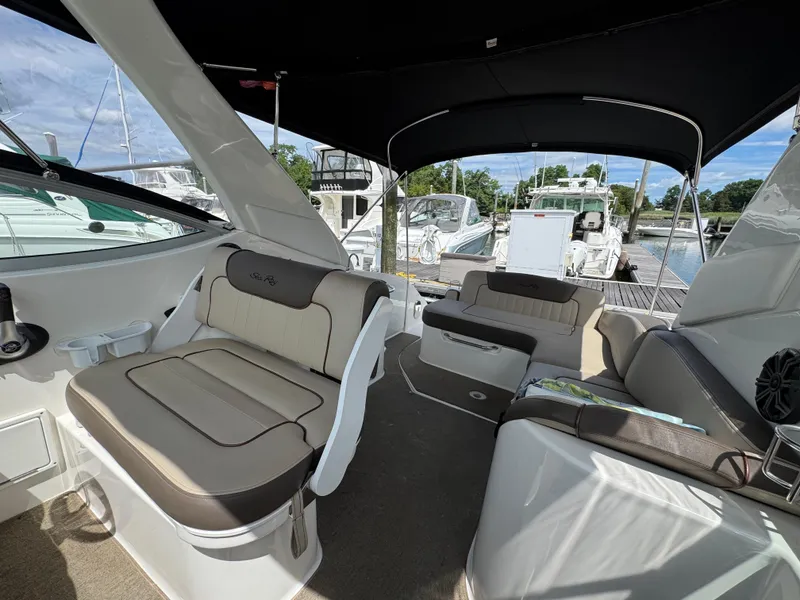 Slide: The Image of Interior of 2014 Sea Ray 280 Sundancer boat with cushioned seating and canopy. - 12