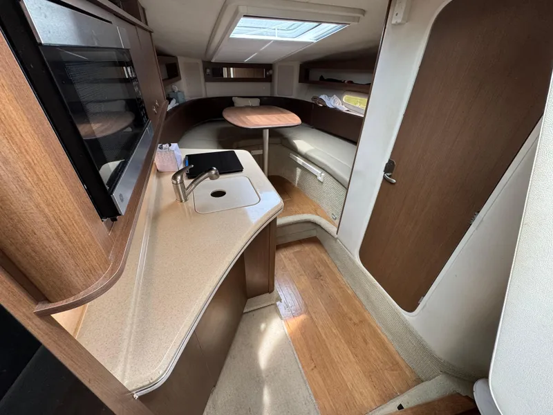 Slide: The Image of 2014 Sea Ray 280 Sundancer cabin interior with kitchenette and seating area. - 16