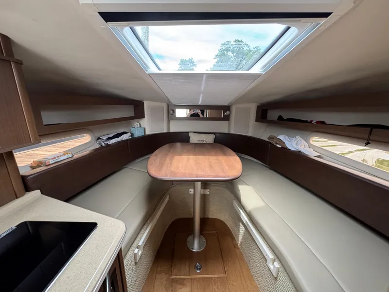 Slide: The Image of Interior of 2014 Sea Ray 280 Sundancer with skylight, table, and seating. - 17