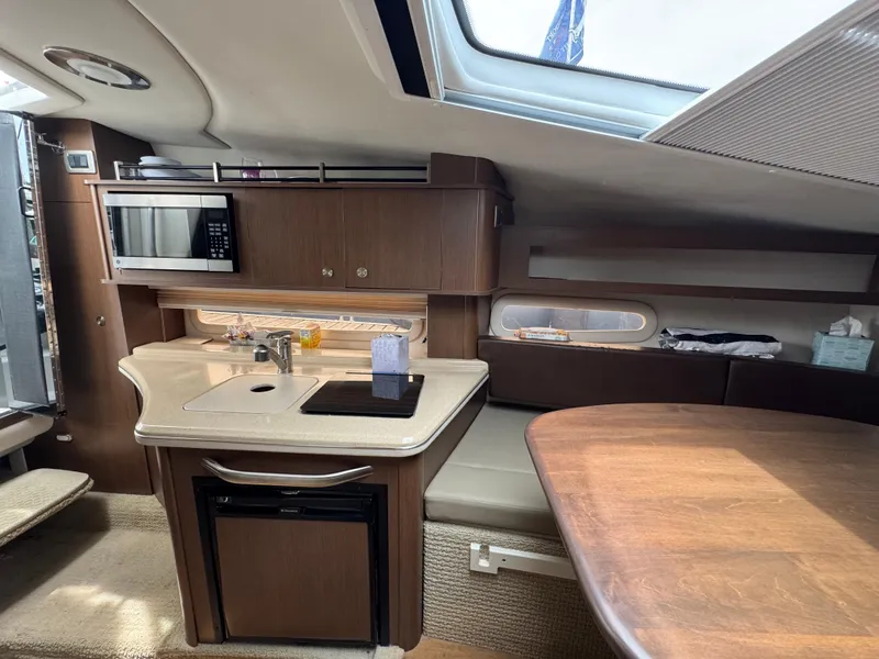 Slide: The Image of Interior of 2014 Sea Ray 280 Sundancer with kitchenette and seating area. - 18