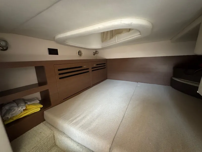 Slide: The Image of 2014 Sea Ray 280 Sundancer cabin interior with bed and storage shelves. - 19