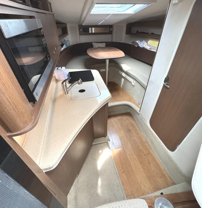 Slide: The Image of Interior of 2014 Sea Ray 280 Sundancer boat with kitchenette and seating area. - 20