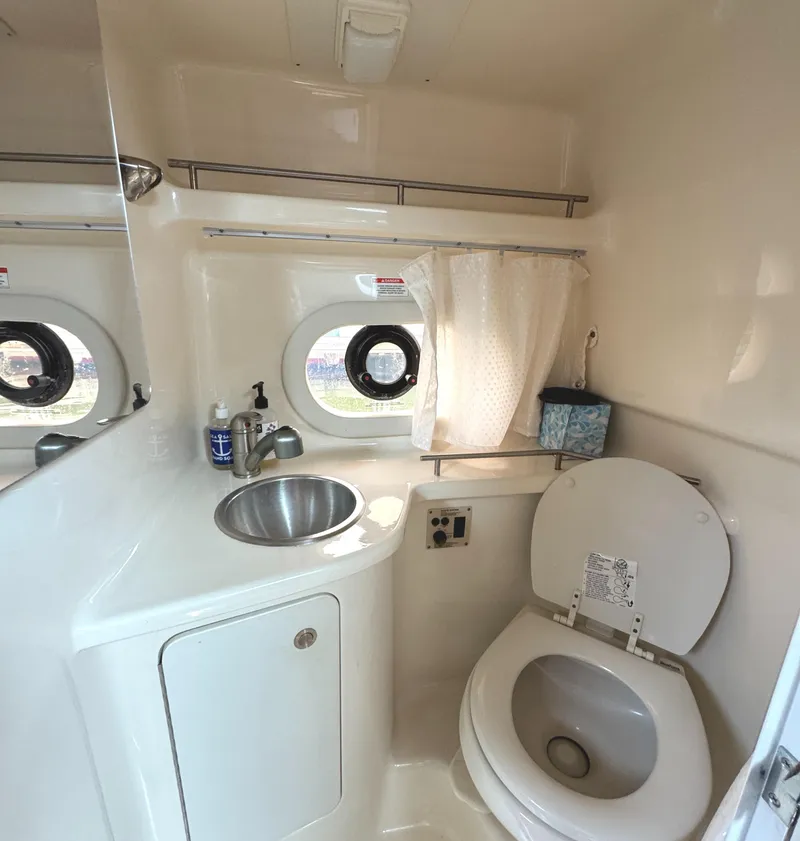 Slide: The Image of 2014 Sea Ray 280 Sundancer bathroom with sink, toilet, and porthole window. - 21