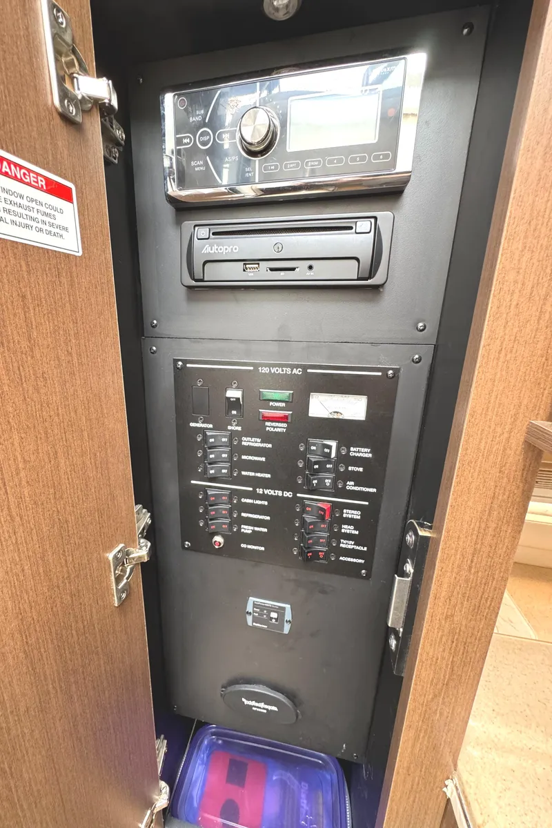 Slide: The Image of Electrical control panel inside 2014 Sea Ray 280 Sundancer boat, featuring stereo and circuit breakers. - 22