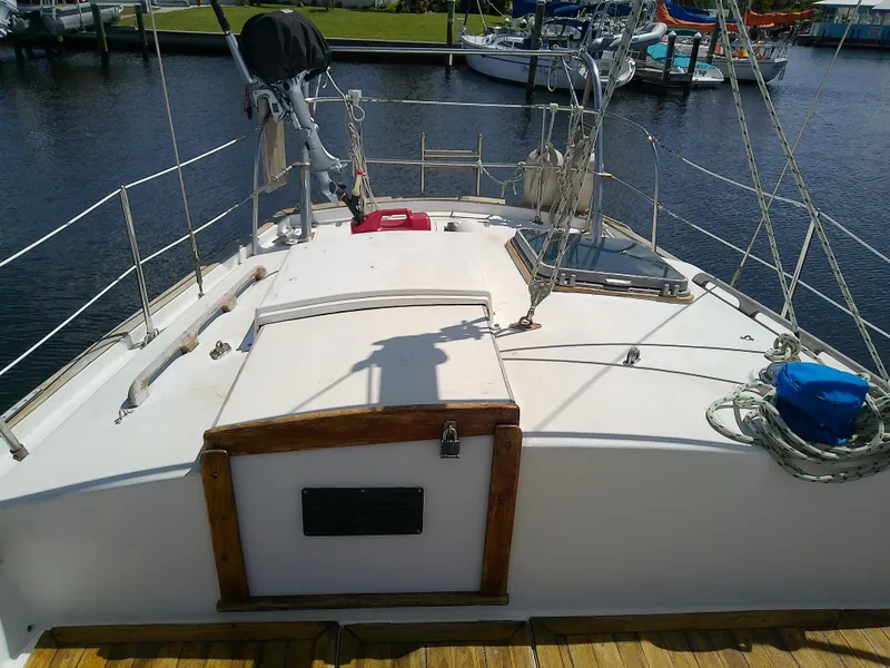 Slide: The Image of Whitby Yachts 42 (1980) sailboat deck with outboard motor and marina view. - 11
