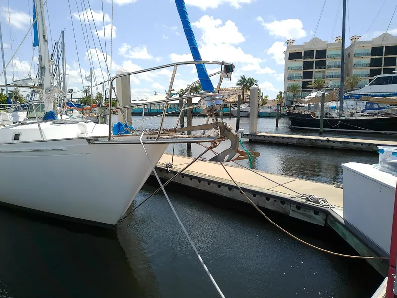 Slide: The Image of 1980 Whitby Yachts 42 sailboat docked in a marina under a clear blue sky. - 3