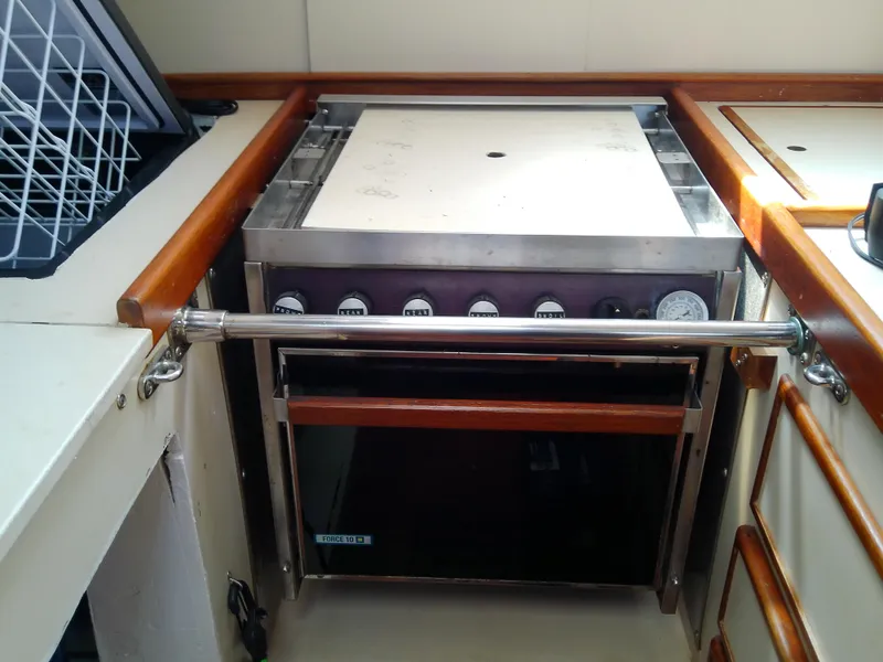 Slide: The Image of Interior of 1980 Whitby Yachts 42, featuring a compact kitchen area with wooden accents. - 31