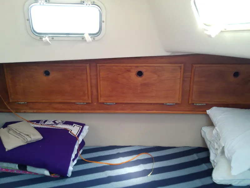 Slide: The Image of Cozy cabin interior of 1980 Whitby Yachts 42 with striped bedding and wooden storage. - 44
