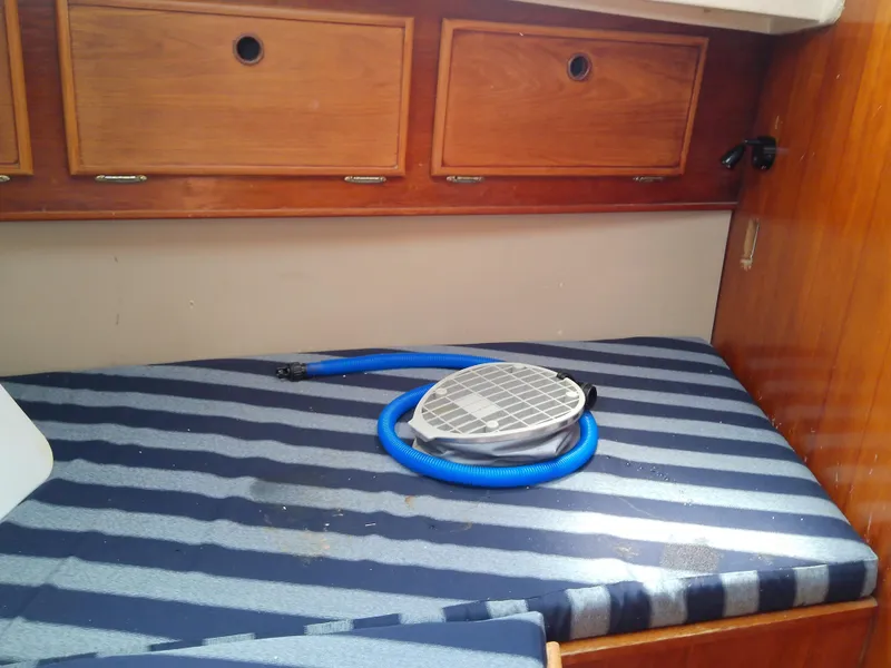 Slide: The Image of 1980 Whitby Yachts 42 interior with wooden navigation desk and cushioned seat. - 47