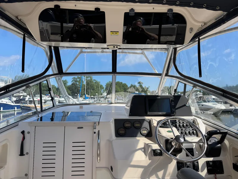 Slide: The Image of 2003 Grady-White Marlin 300 boat cockpit with steering wheel and navigation controls. - 11
