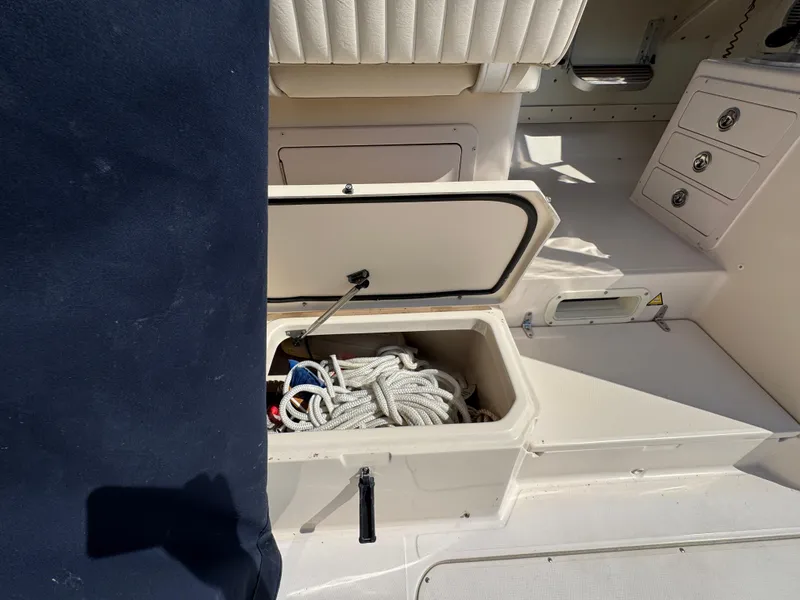 Slide: The Image of 2003 Grady-White Marlin 300 boat storage compartment with ropes and seating. - 12