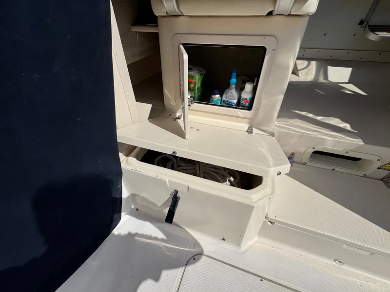 Slide: The Image of 2003 Grady-White Marlin 300 boat storage compartments with supplies and rope. - 13