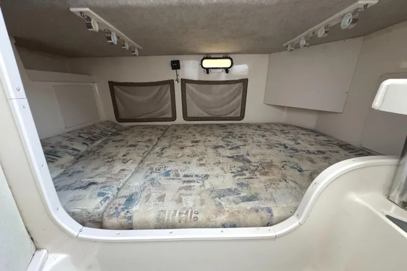 Slide: The Image of 2003 Grady-White Marlin 300 cabin interior with cushioned sleeping area and storage compartments. - 33