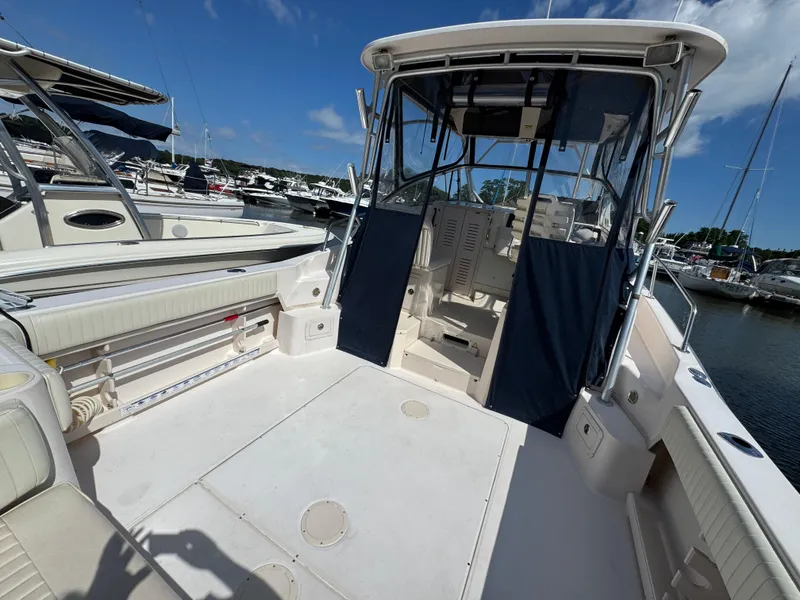 Slide: The Image of 2003 Grady-White Marlin 300 boat interior at marina, featuring spacious deck and seating. - 4
