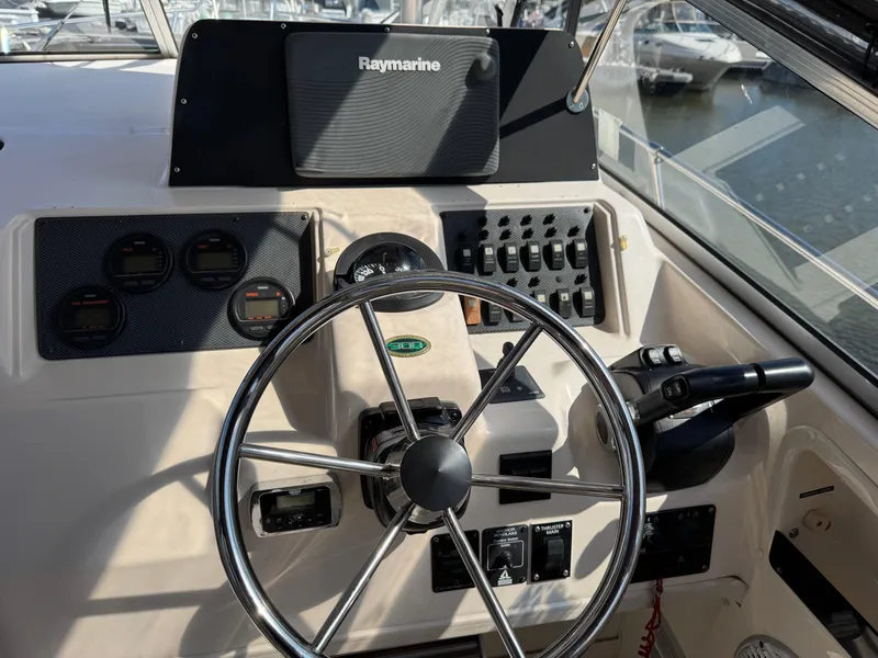 Slide: The Image of 2003 Grady-White Marlin 300 boat dashboard with steering wheel and Raymarine navigation system. - 8